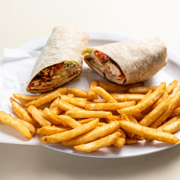 Two chicken wraps with fresh vegetables and a side of golden french fries on a white plate.
